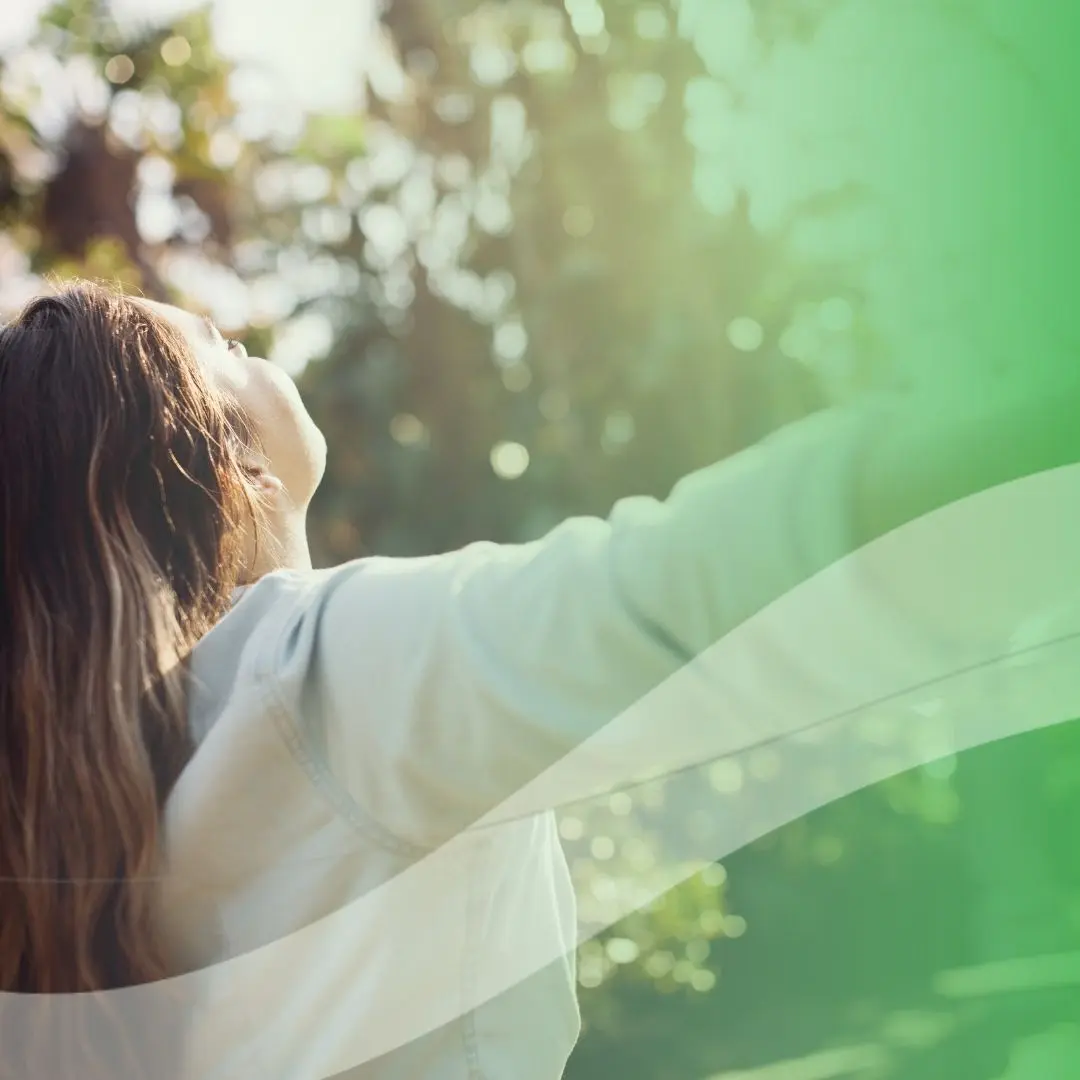 Woman looking up joyfully outdoors